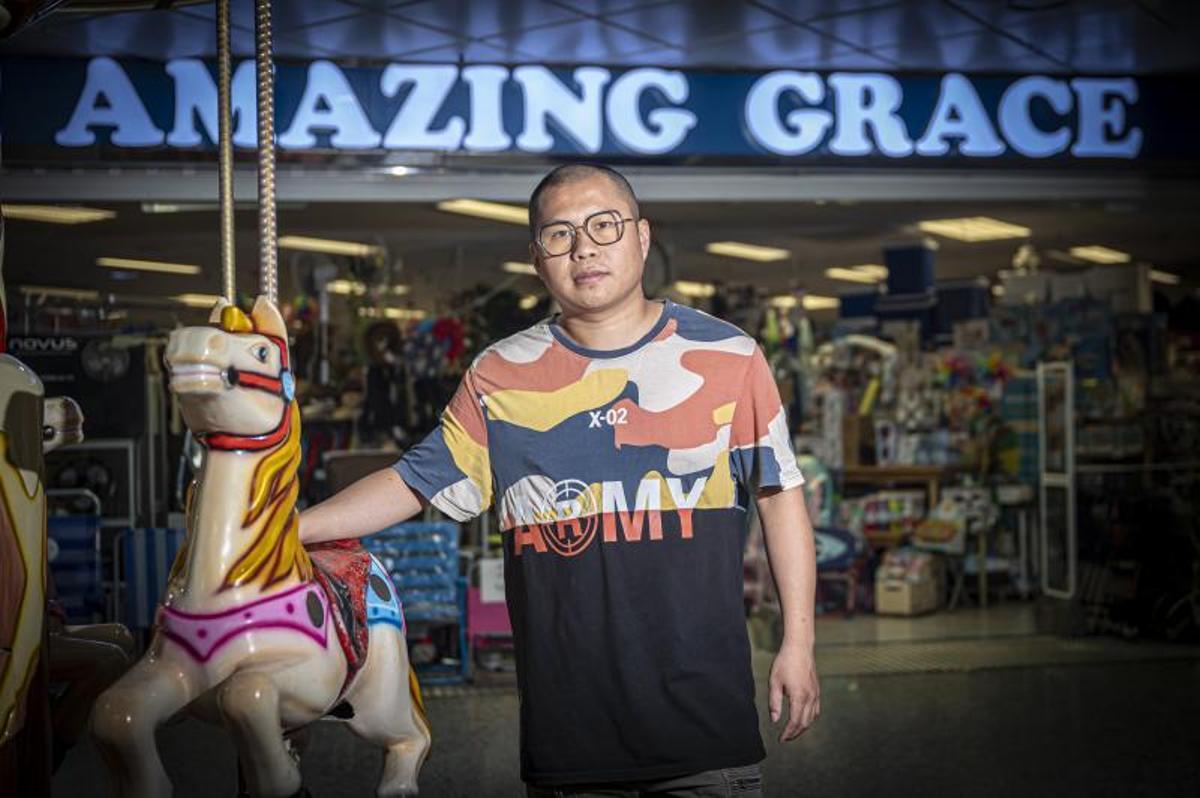 Chengbo a cargo de la tienda 'Amazing Grace' del centro comercial.