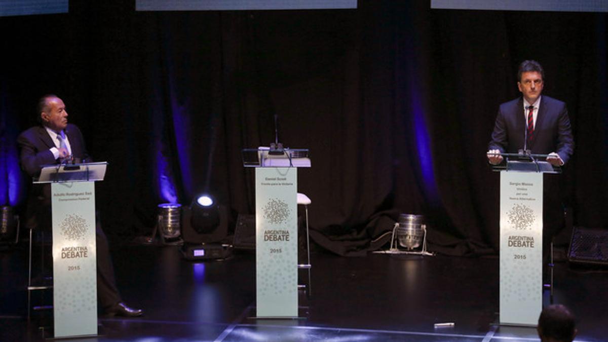 Los candidatos Adolfo Rodriguez Saa (izquierda) y  Sergio Massa, junto al atril vacío del kirchnerista Daniel Scioli, en Buenos Aires.