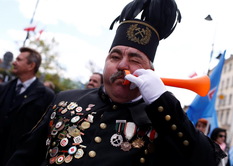 A miner blows a horn during the May Day rally in ...