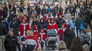 Una familia pasea esta tarde de domingo vestida de Papa Noel por el centro de Barcelona.