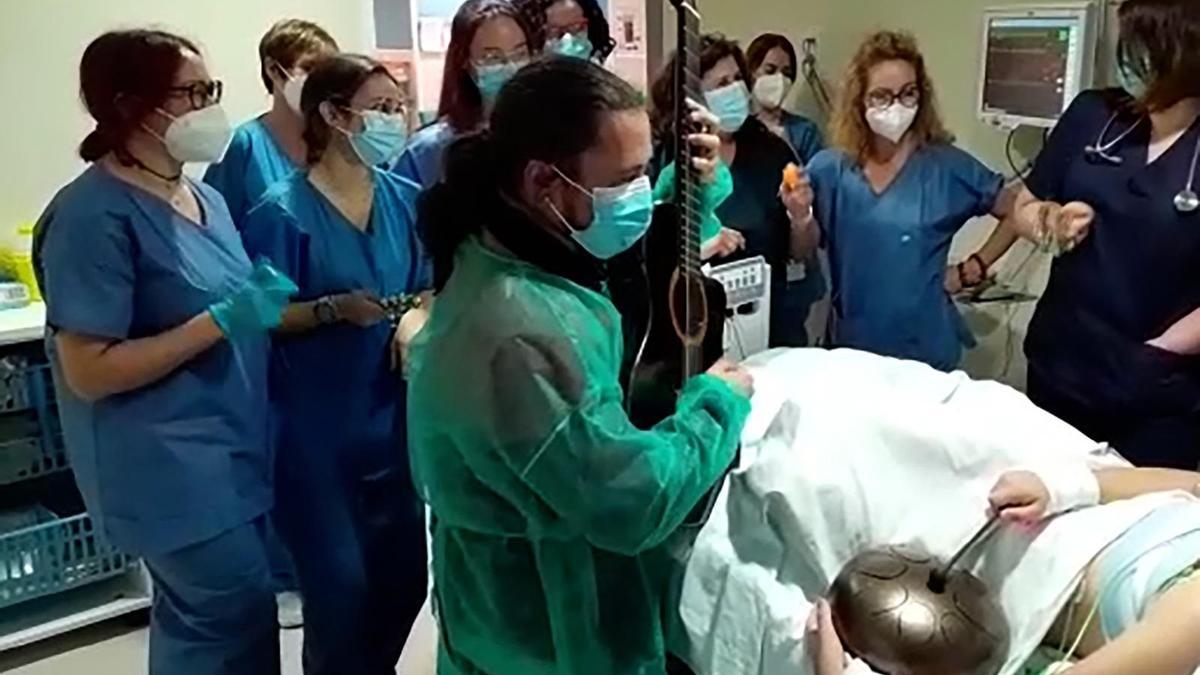 El musicoterapeuta Javier Alcántara en una sesión con un paciente ingresado en la UCI, junto a otros profesionales sanitarios.