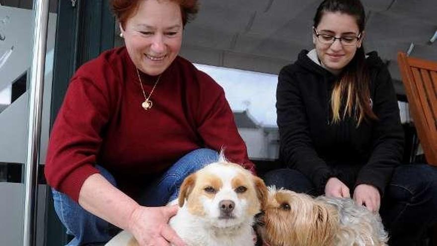 La hija de los propietarios del restaurante (dcha.) y una vecina con sendos perros adoptados.  // Bernabé/Javier Lalín