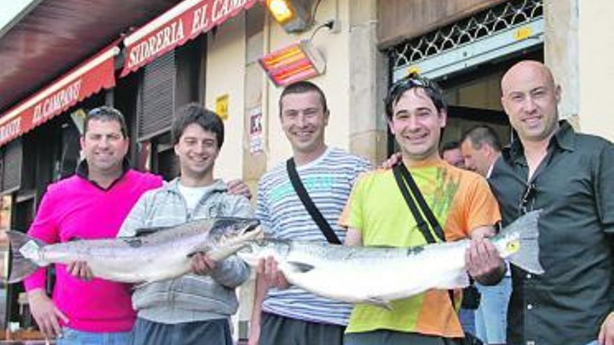 Andoni Vallate y Josu Ruiz, segundo y tercero por la derecha, posan con los salmones y el comprador del campanu, José M. Mori, primero por la izquierda.