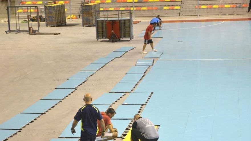 Operarios colocando la pista azul de partidos televisados.