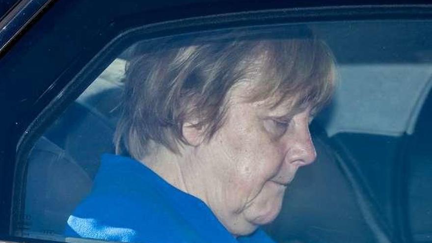 Merkel, ayer, en el interior de su coche oficial. // AFP