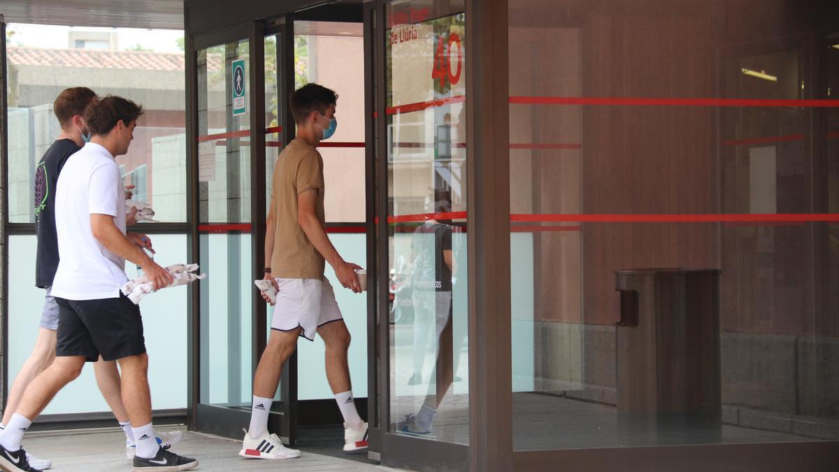 Tres estudiants entrant a l&#039;edifici del campus Ciutadella de la Universitat Pompeu Fabra.