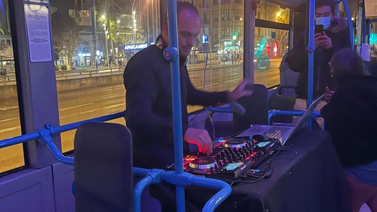 Un DJ ameniza, anoche, el trayecto en el estreno de las «paradas violeta» del NitBus. | AJUNTAMENT