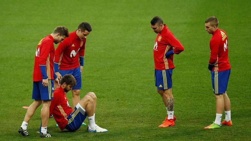 Illarramendi, Herrera, Iago Aspas y Deulofeu observan a Piqué, dolorido de un golpe, en el entrenamiento en Saint-Denis. // Gonzalo Fuentes