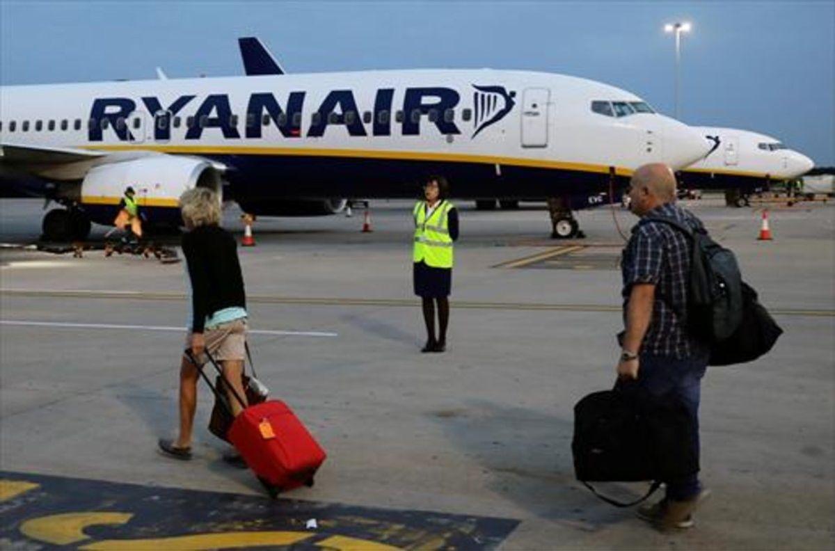 Pasajeros de Ryanair trasladando el equipaje a la aeronave.