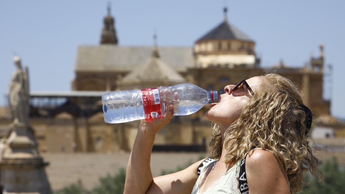 CÓRDOBA, 11/06/2022.- Una turista bebe agua para combatir el calor, en Córdoba, este sábado. La Aemet ha informado de que desde mañana empieza un episodio de ola de calor y las temperaturas máximas es muy probable que lleguen a 34-36 grados de forma bastante generalizada en el interior peninsular y Mallorca; aunque podrían alcanzar entre 40 y 43 grados en el valle del Guadalquivir. EFE/Salas