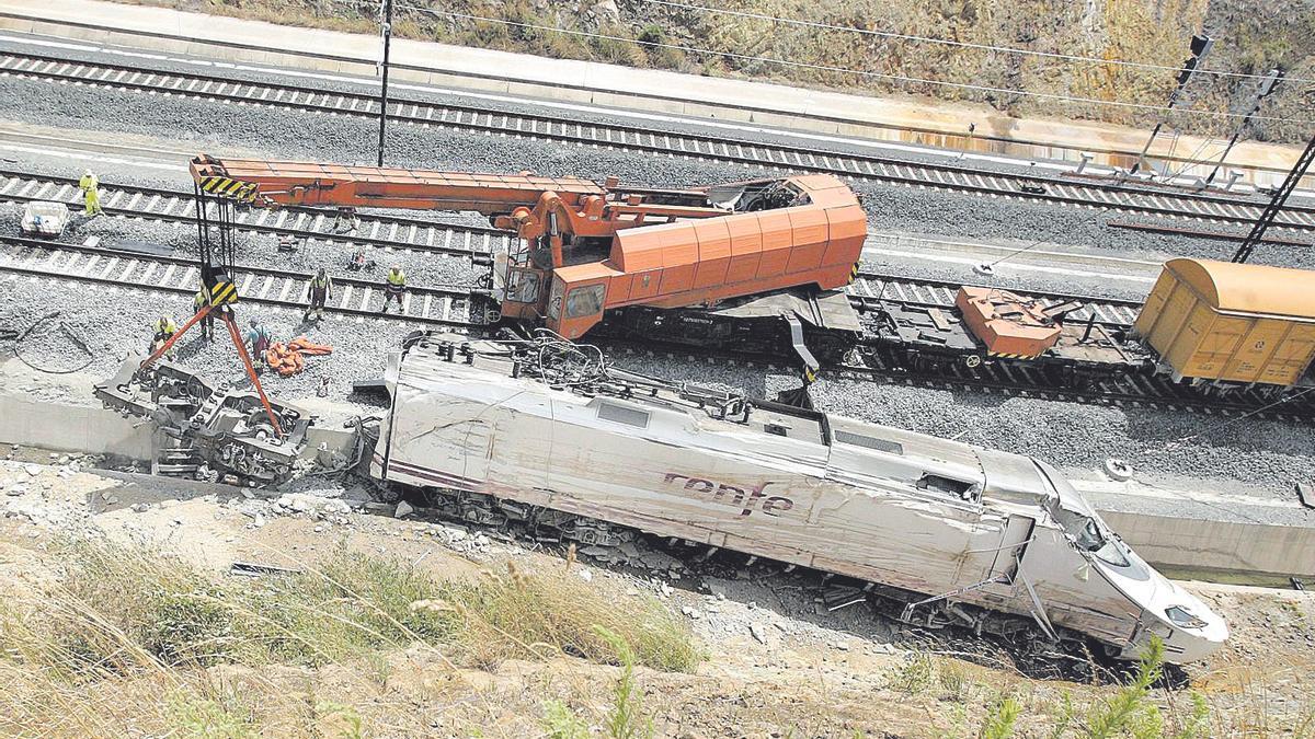 Técnicos retirando de la vía los restos del tren descarrilado