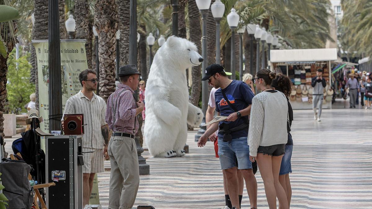 En primer término, fotógrafos vestidos de época. Tras ellos, un oso polar gigante. Al fondo, los «hippies» que el Ayuntamiento eliminará en octubre.