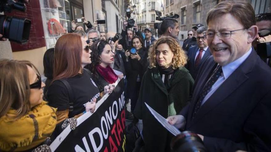 La ministra de Política Territorial, Meritxell Batet, y el presidente de la Generalitat, Ximo Puig, atienden ayer frente al Palau una protesta de funcionarios de prisiones.