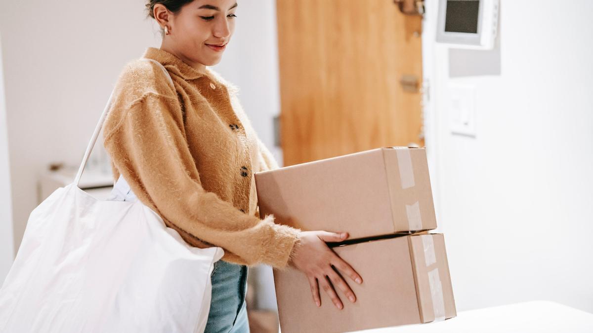 Una joven sujeta dos cajas, en una imagen de archivo