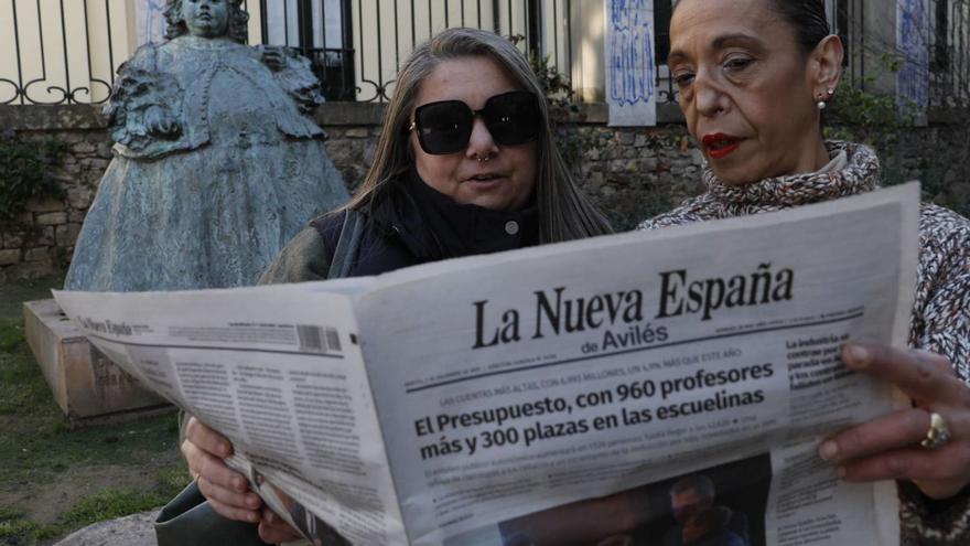 Paula López y Begoña Redondo, leyendo LA NUEVA ESPAÑA ante la escultura de «La Mi Nena». | MARA VILLAMUZA
