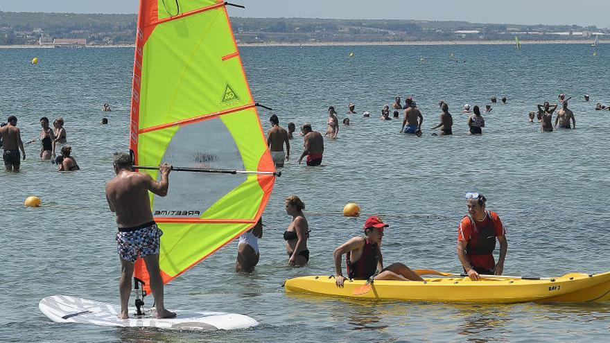 Un aficionado practica windsurf durante el verano en una playa de Santa Pola, en imagen de archivo.