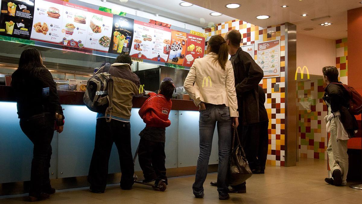 Local de comida rápida en Barcelona, en el que se ven reflejados los carteles de otro restaurante