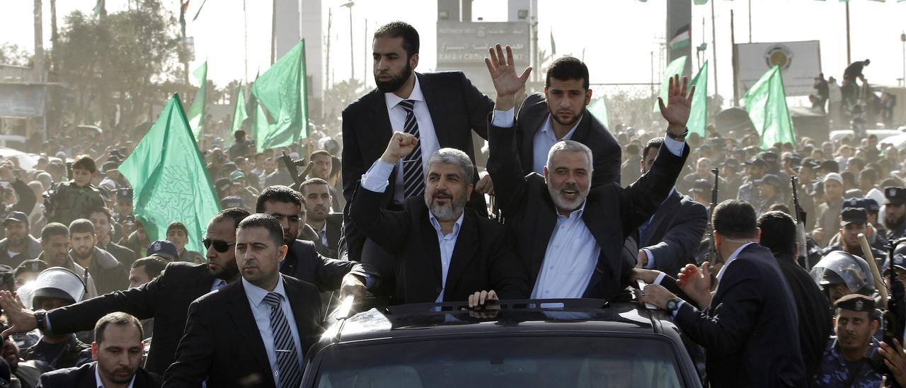 Los líderes de Hamás, Ismail Haniyeh y Khaled Meshal, saludan a sus seguidores al entrar en Gaza en diciembre de 2012.