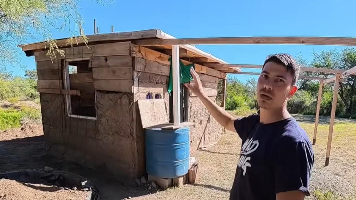 Mauricio construye una casa de madera, paja y barro en el monte.