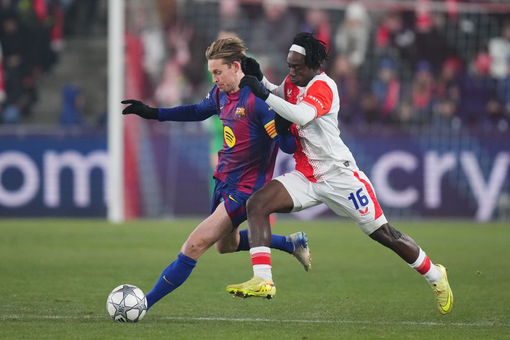 Barcelona's Frenkie de Jong, left, is challenged by Slavia's David Moses during the Champions League opening phase soccer match between Slavia Prague and Barcelona in Prague, Czech Republic, Wednesday, Jan. 21, 2026. (AP Photo/Petr David Josek)