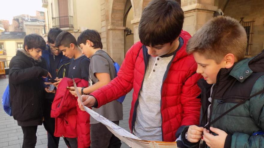 Un grup d&#039;estudiants del Lluís de Peguera amb els mòbils i el mapa davant l&#039;Ajuntament