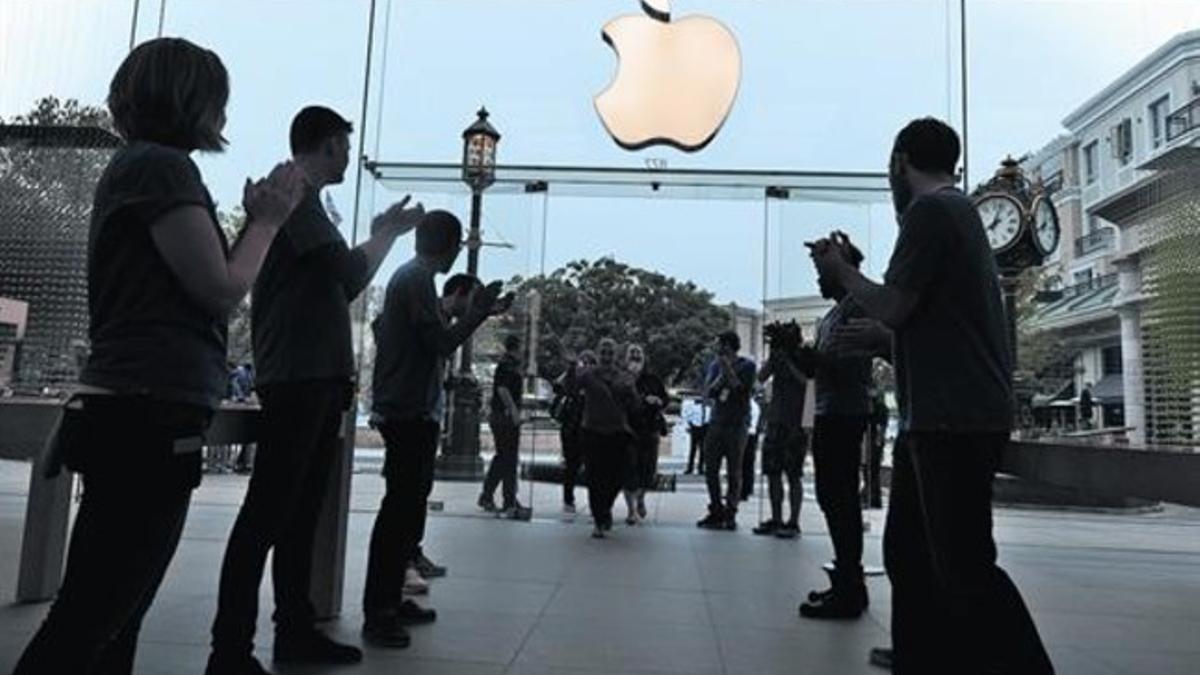 Empleados de Apple reciben con aplausos a los primeros clientes llegados para comprar el iPhone 5 en Glendale (California), en septiembre del 2013.