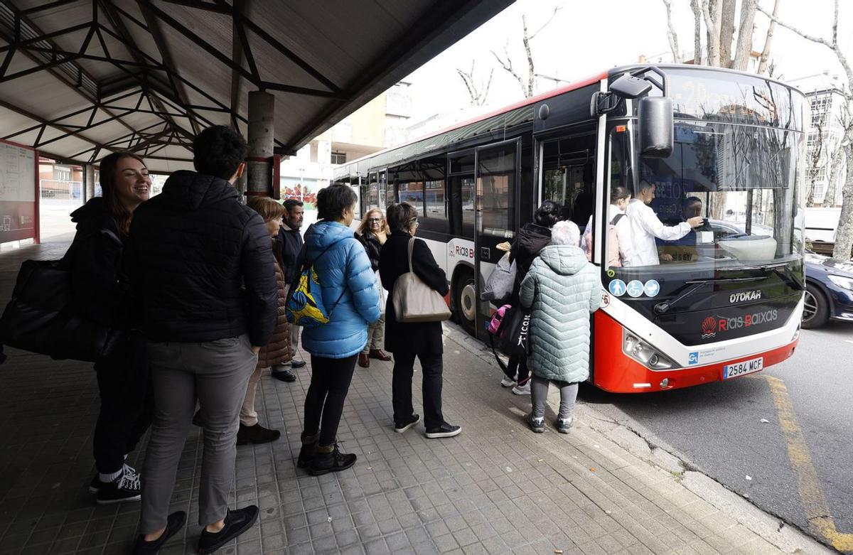 Usuarios aguardan a subir al autobús en la marquesina del autobús de plaza de Galicia.  | // GUSTAVO SANTOS