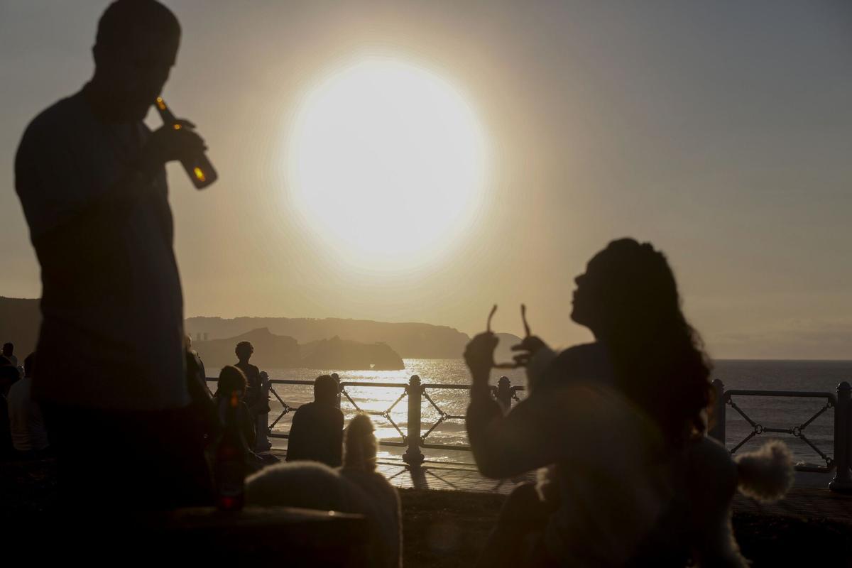 PERSONAS CONTEMPLANDO LA PUESTA DE SOL EN LA PLAYA DE SALINAS