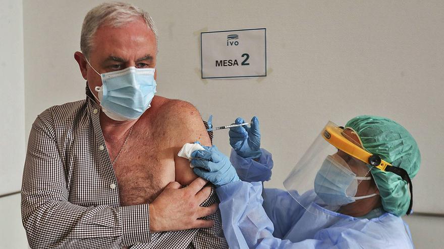 Una enfermera del Instituto Valenciano de Oncología (IVO) vacuna a un trabajador del centro, ayer. | F. CALABUIG