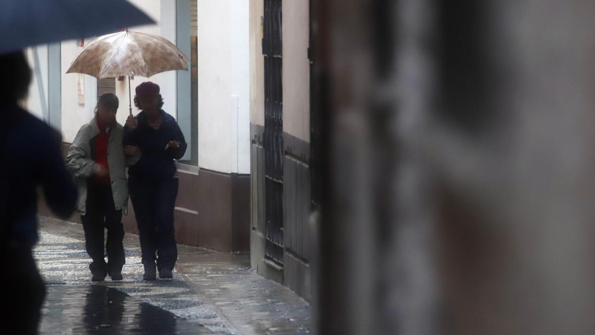 La gente se protege de la fuerte lluvia en Málaga, este 9 de diciembre.