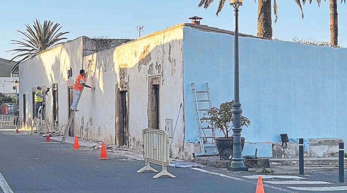 Dos operarios trabajan en mejorar las fachadas de Betancuria.