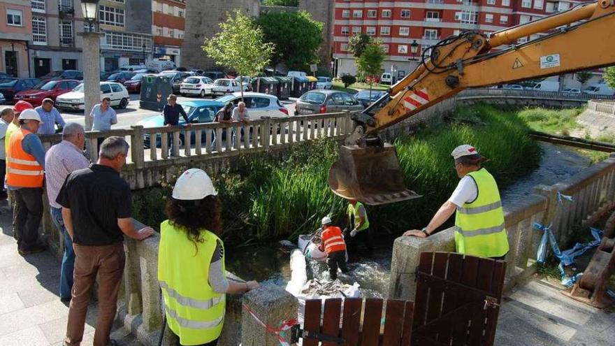 Unos operarios trabajan ayer en el cauce del río Maceiras con la ayuda de una excavadora. // FdV