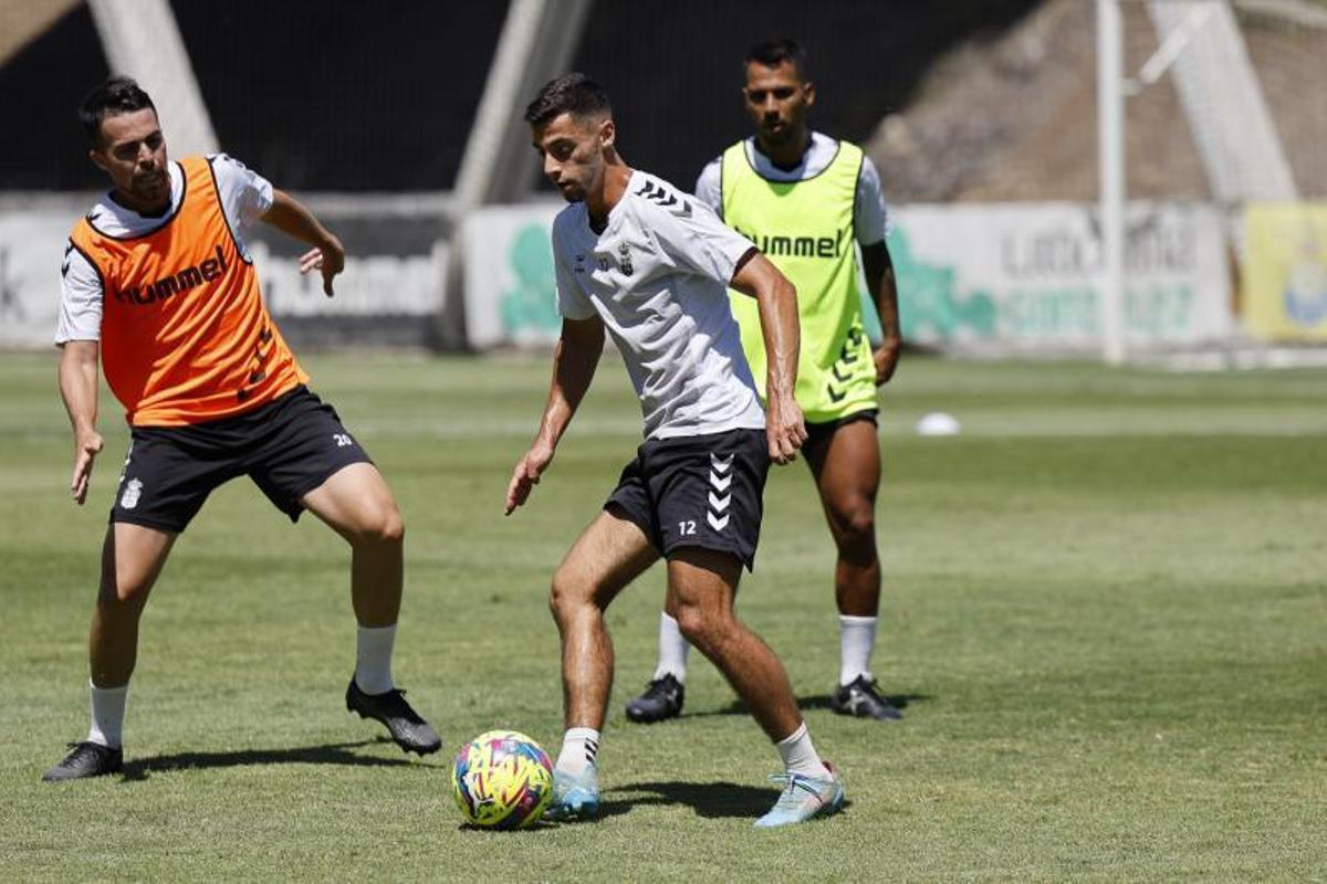 Enzo Loiodice maneja el balón presionado por Kirian Rodríguez, con Jonathan Viera detrás, durante el entrenamiento de ayer en Barranco Seco.