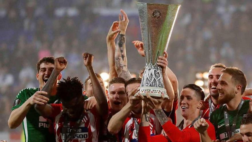 Fernando Torres y Gabi levantan el trofeo de la Liga Europa jaleados por sus compañeros.