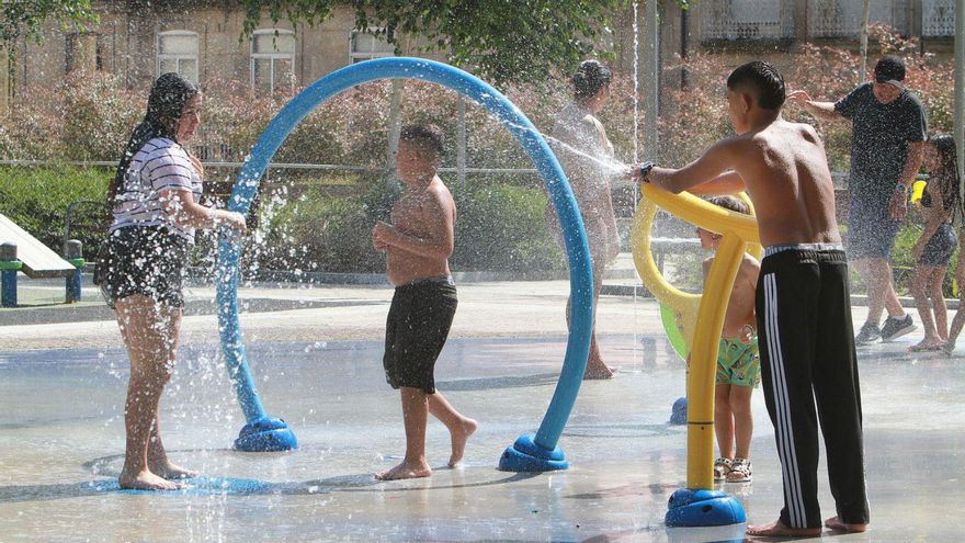 Un grupo de jóvenes se refrescan con agua, ayer, en Ourense. | Iñaki Osorio