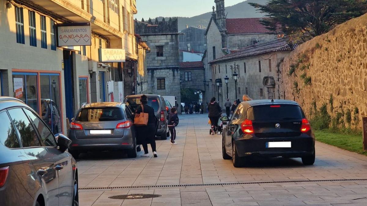 Vehículos aparcados en la parte alta. Al fondo, el convento y el colegio. |   //  M.M.