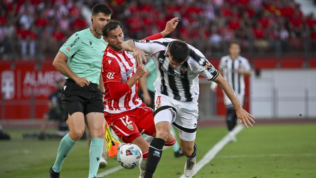 ALMERÍA, 09/06/2026.- El defensa del Castellón Agustín Sienra (d) trata de escapar de Leo Baptistao (c), del Almería, durante el partido de vuelta de las semifinales del ascenso a Primera División que UD Almería y CD Castellón disputan este martes en el UDA Stadium de Almería. EFE/Carlos Barba