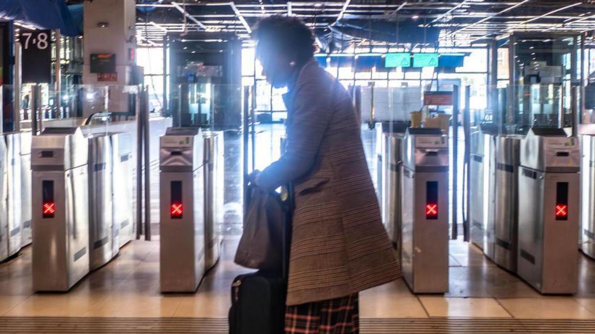 Una dona amb maleta, ahir en una deserta estació de Sants.  | JORDI OTIX