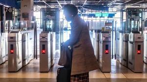 Una dona amb maleta, ahir en una deserta estació de Sants.  | JORDI OTIX