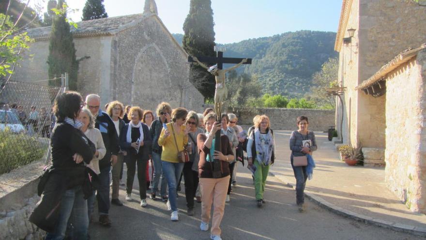 Un grupo de fieles transporta el Sant Crist de Sant Miquel en procesión, en el exterior de la ermita.