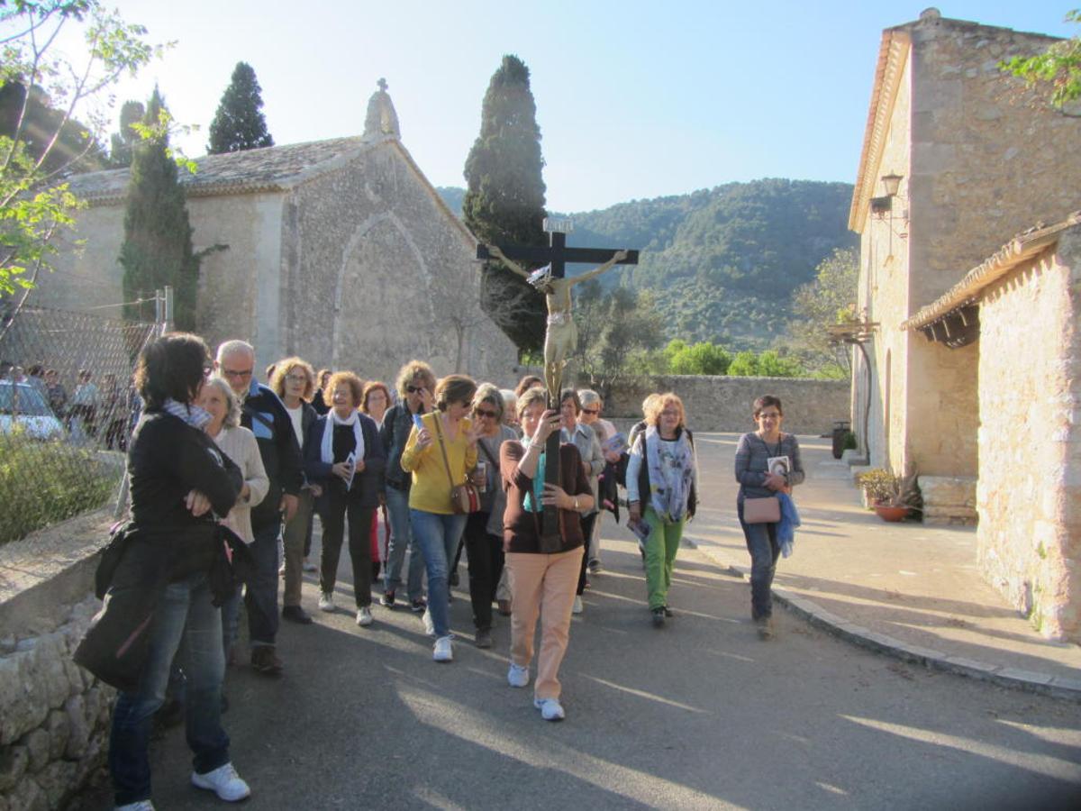 Un grupo de fieles transporta el Sant Crist de Sant Miquel en procesión, en el exterior de la ermita.