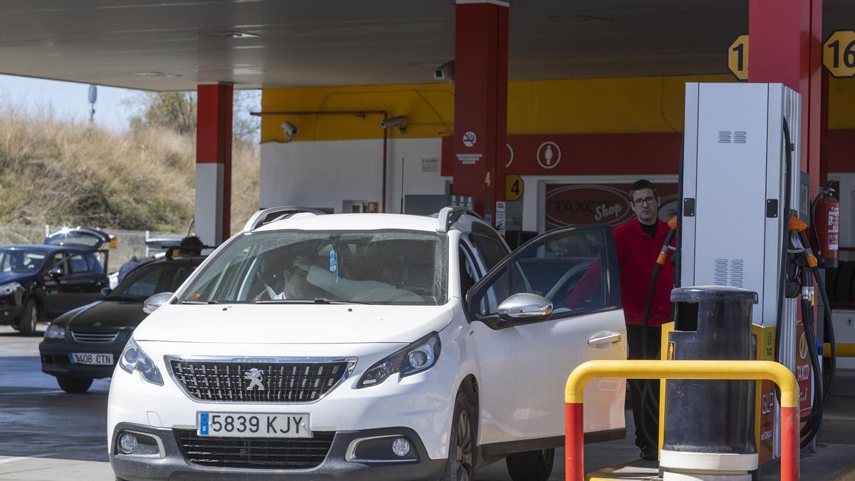 Personas repostando en una gasolinera de València.