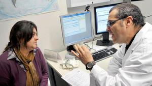 Un médico de un CAP de Salt (Gironès) habla con una paciente en su consulta.