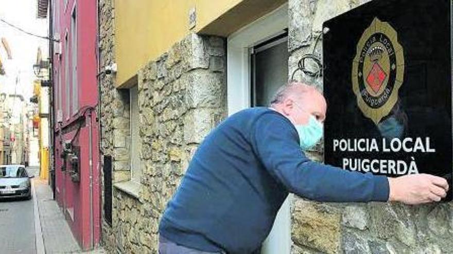 Un treballador instal·la el nou cartell de la Policia Local a la nova seu