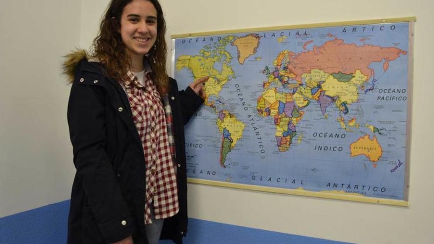 Lucía Pidal señala Canadá en un mapa de su instituto, en Luces (Colunga).