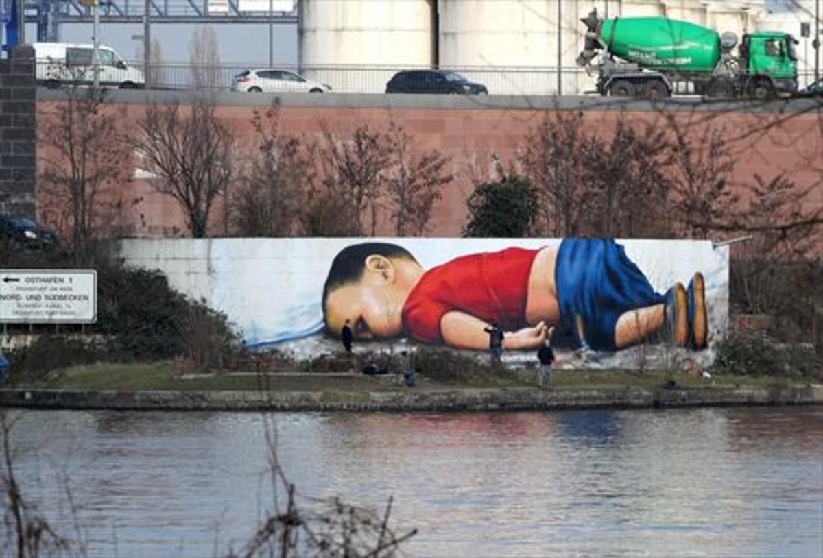 Un enorme grafiti de Aylan ocupa un muro junto al río Main en Fráncfort.