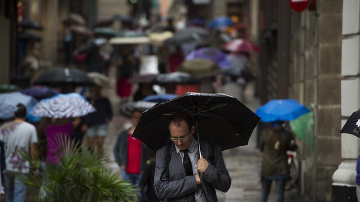 Viandantes se protegen de la lluvia con paraguas por las calles del barrio gotico el pasado septiembre