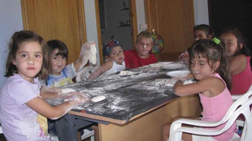 Los niños y niñas elaborando barras de pan en el campamento de Vigo de Sanabria.