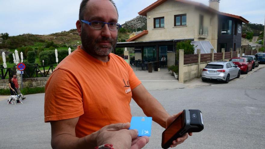 El propietario de uno de los restaurantes de Donón, buscando cobertura en el exterior del local para cobrar con tarjeta. | Gonzalo Núñez