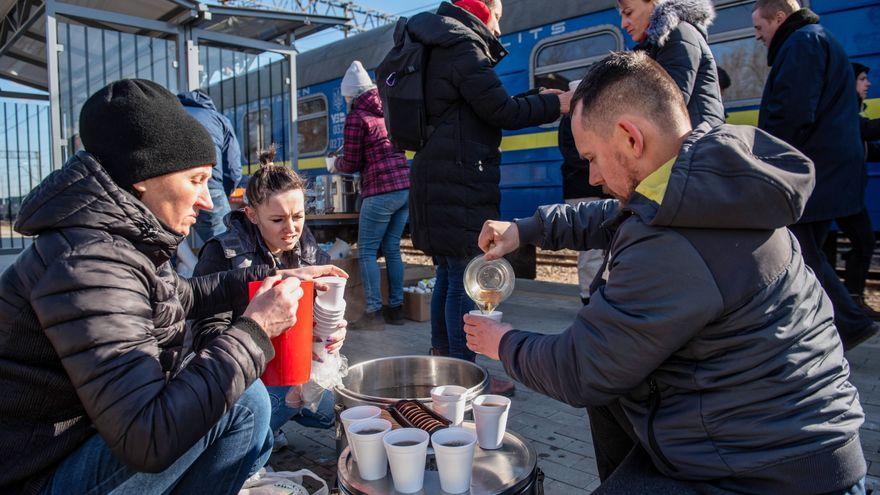 Refugiados ucranianos toman una bebida caliente en la frontera de Dorohusk.